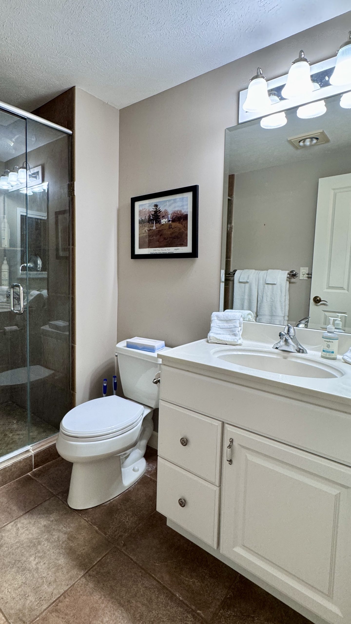 Primary bathroom with a white vanity, toilet and framed art at BeachComber 15