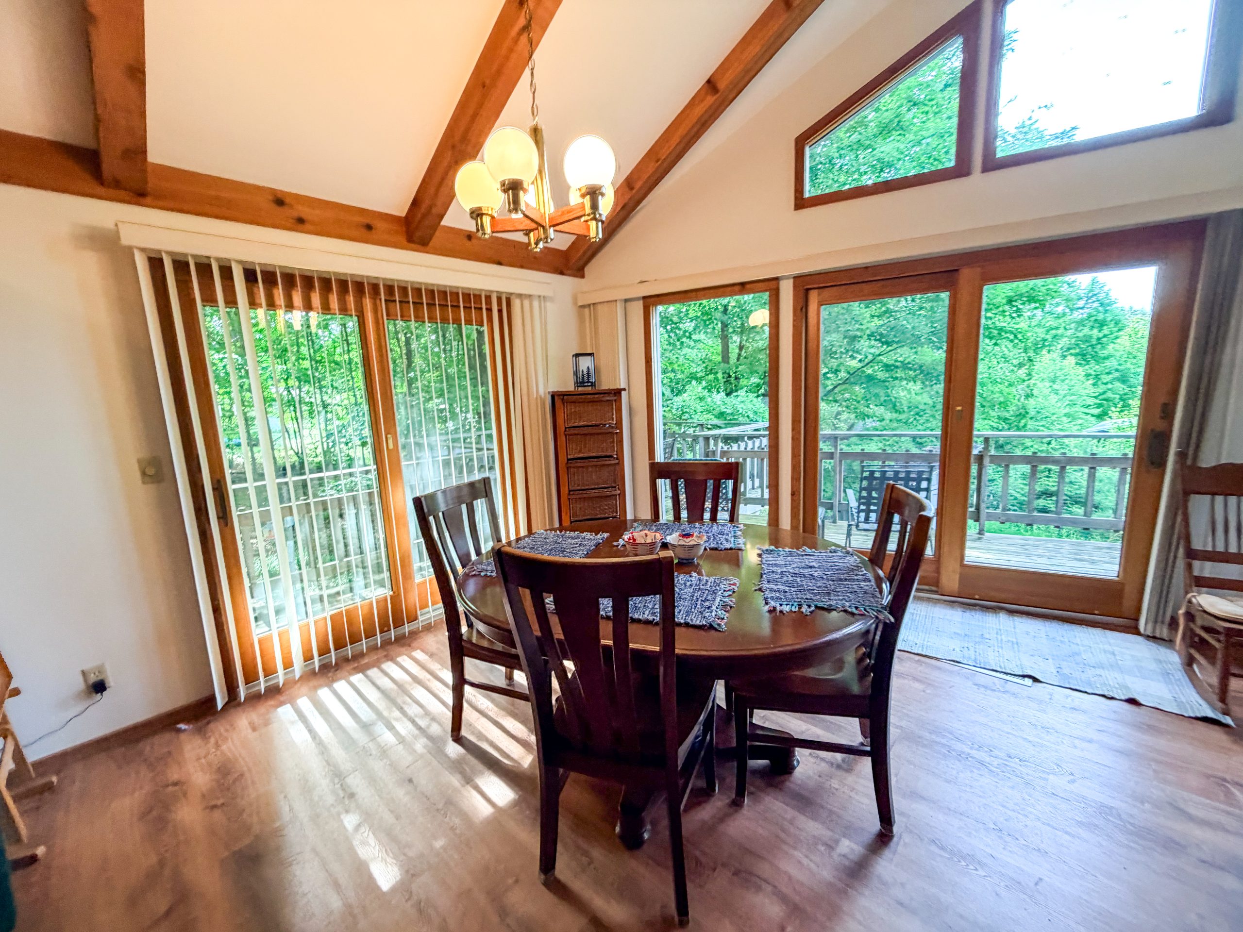 Dining table with four chairs in front of tall glass doors at Empire Escape